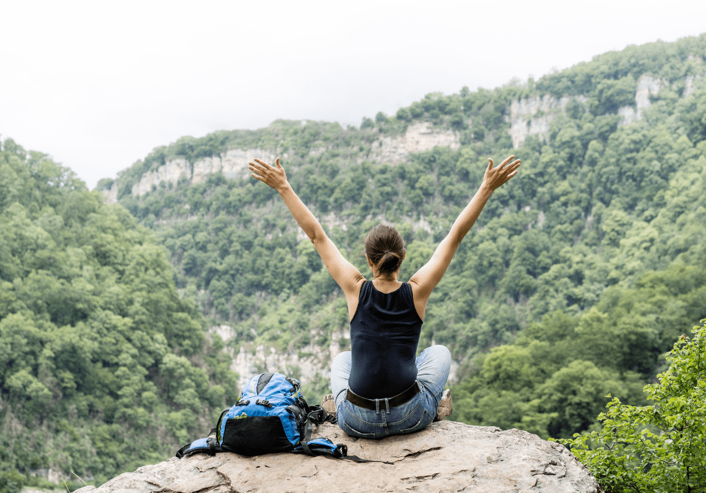 una donna guarda la natura in montagna di spalle